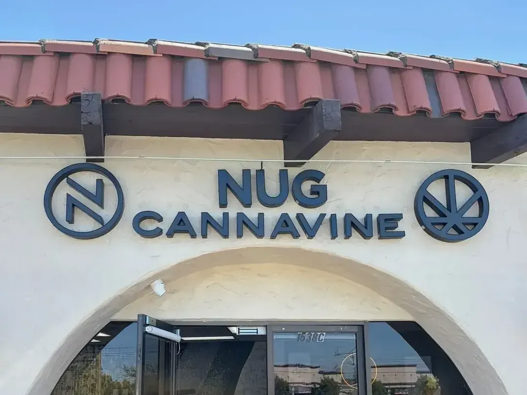 Nug Cannavine storefront with red tile roof and arched entrance